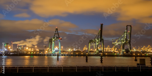 Industrial Harbor quay with loading cranes at night
