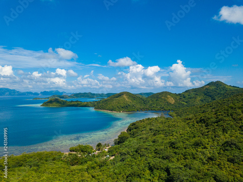 Aerial view of tropical island Bulalacao. Beautiful tropical island with white sandy beach  palm trees and green hills. Travel tropical concept. Palawan  Philippines