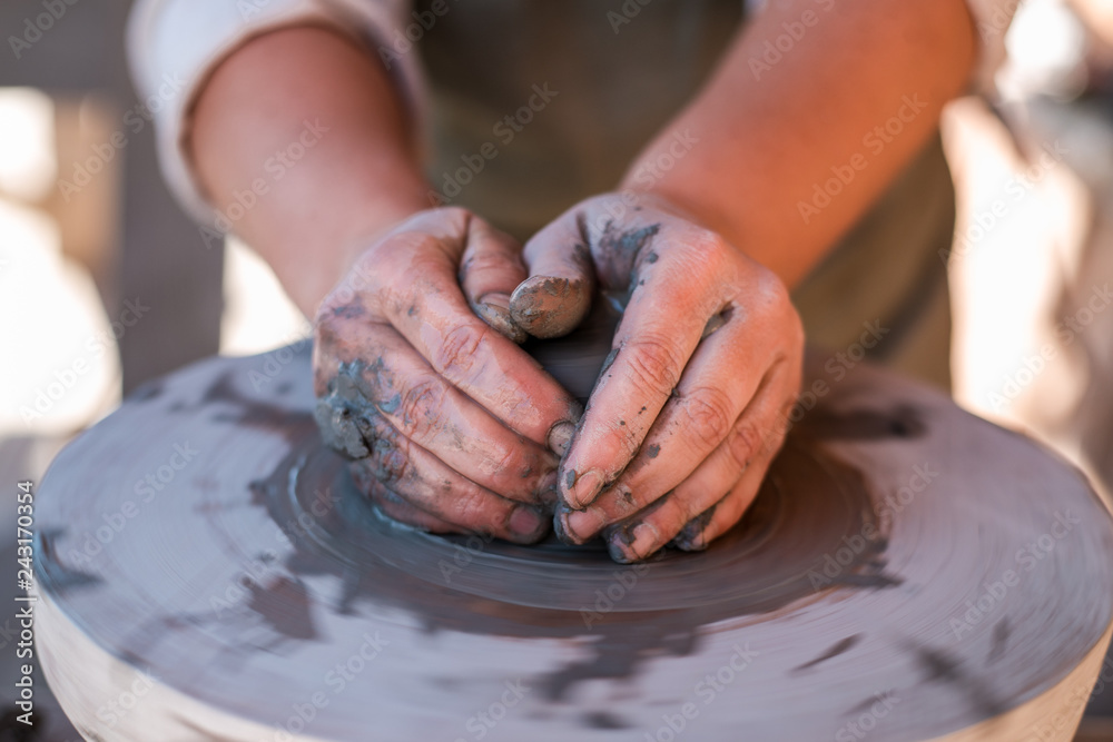 Potter is creating earthenware on potter's wheel.