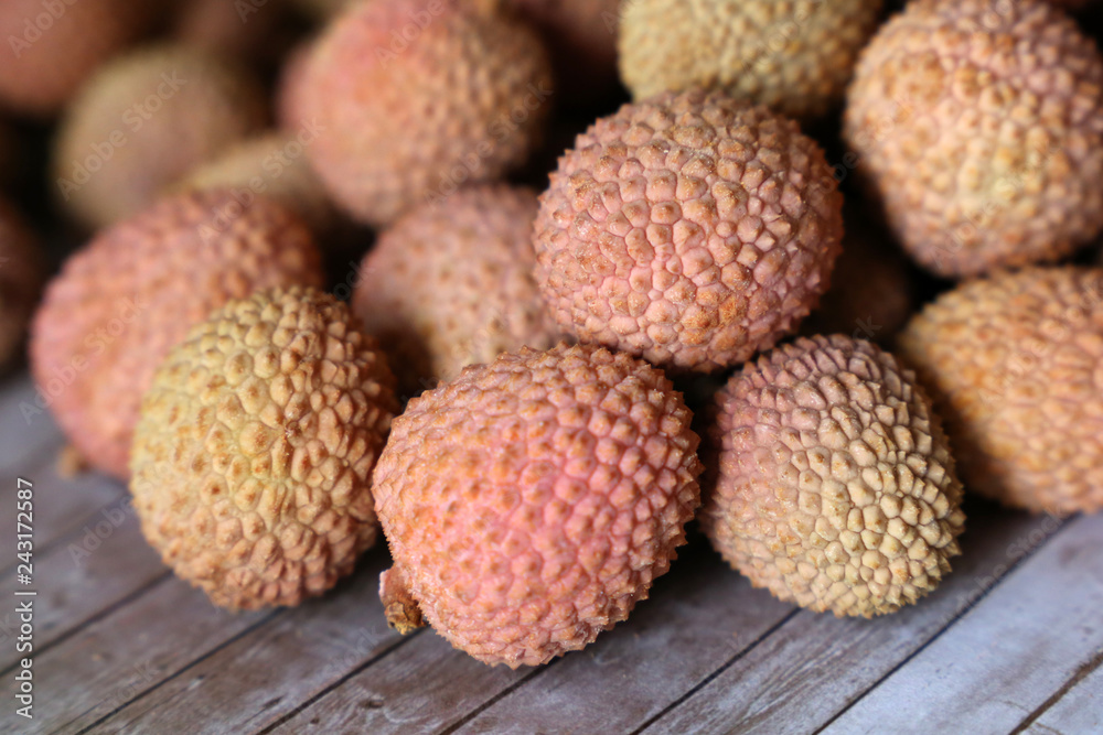Lychees on a wooden table. Fresh harvest of exotic fruit lychee