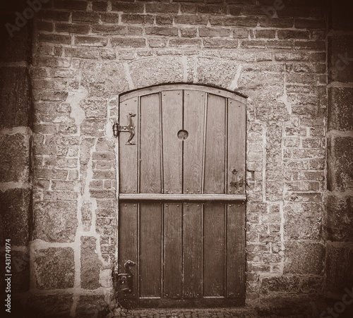 Old church door in brick wall. Bremen, Germany . Image in sepia color style