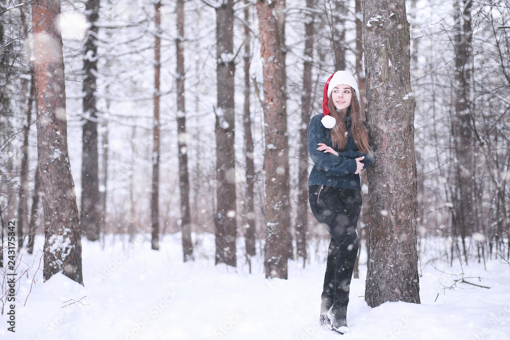 Girl in a winter park in snowfall