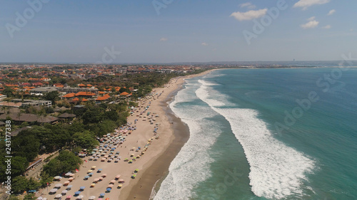 Aerial view sand beach with resting people, hotels and tourists, sun umbrellas, Bali, Kuta. surfers on water surface. Seascape, beach, ocean, sky sea Travel concept