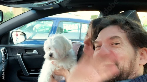 Happy couple in car doing selfie video with dog playing photo