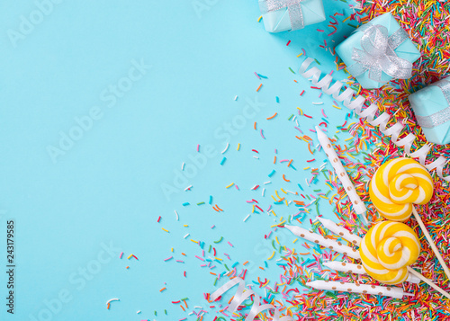 Birthday and party concept background with confetti, decoration and lollipop on blue
