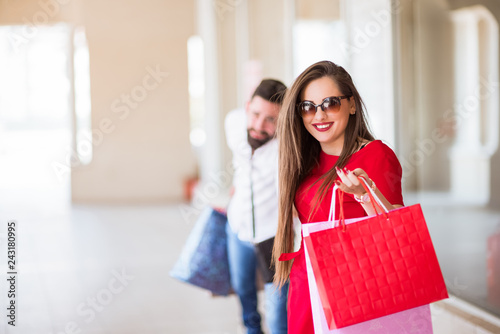 Smiling Couple Holding Colorful Shopping Bags