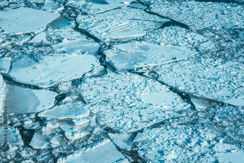 Aerial view of frozen lake. Cracked Ice from drone view. Background texture concept
