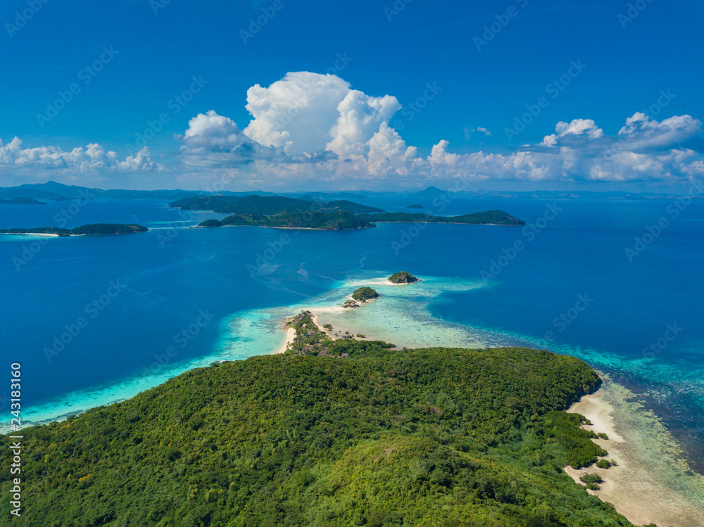 Fototapeta premium Aerial view of tropical island Bulalacao. Beautiful tropical island with white sandy beach, palm trees and green hills. Travel tropical concept. Palawan, Philippines