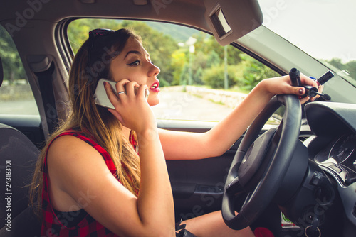 Girl having conversation on phone while driving, reckless driving photo