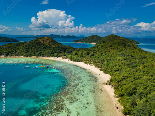 Aerial view of tropical beach of island Bulalacao. Beautiful tropical island with white sandy beach, palm trees and green hills. Travel tropical concept. Palawan, Philippines