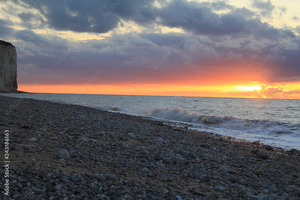 beautiful sunset at sea at the cliff coast in normandy with an orange stripe in the sky beautiful sunset at sea at the cliff coast in normandy with an orange stripe in the sky