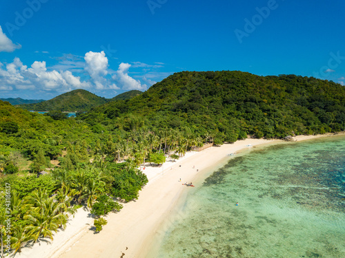 Aerial view of tropical beach of island Bulalacao. Beautiful tropical island with white sandy beach, palm trees and green hills. Travel tropical concept. Palawan, Philippines