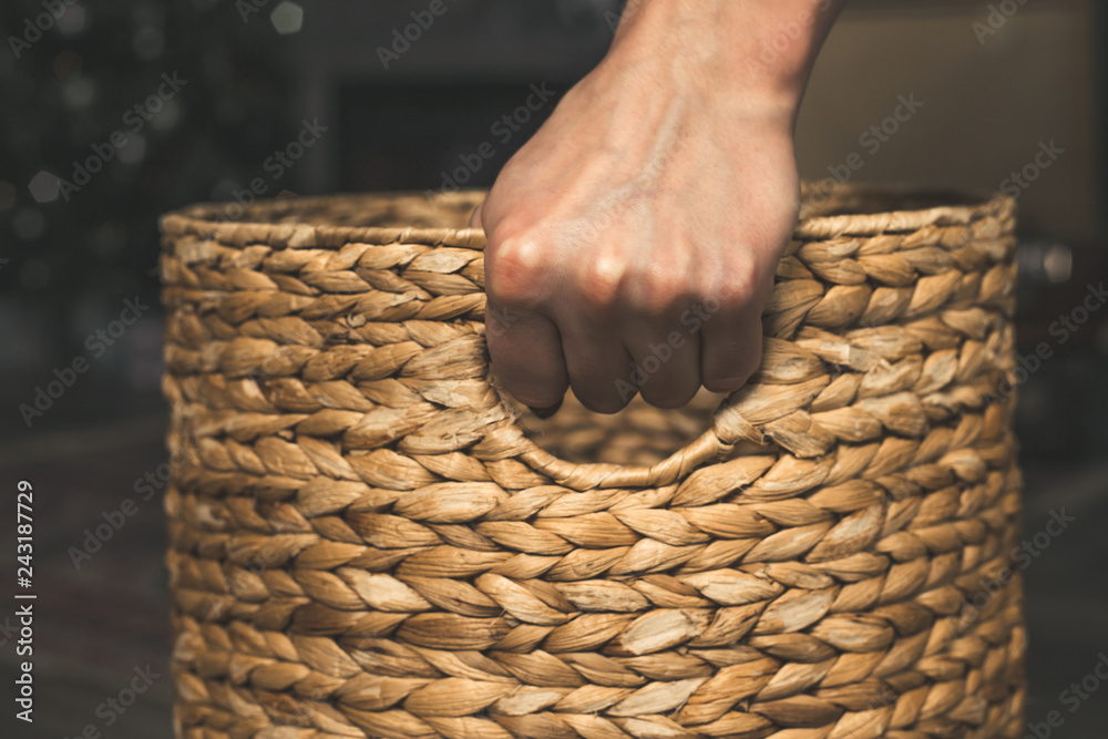 Obraz premium Hand holds old wicker basket in dark colors.