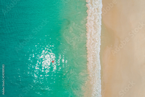 Aerial view of slim woman swimming on the swim ring  donut in the transparent turquoise sea in Seychelles. Summer seascape with girl, beautiful waves, colorful water. Top view from drone © gawriloff