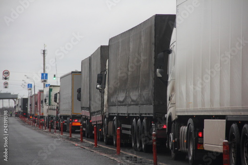 Fotografie Truck inspection - a long congestion traffic of many trucks with semi trailers convoy on weight control point