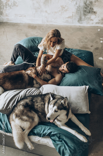 Beautiful loving couple in bed together with the dog