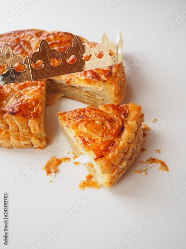 Homemade Epiphany cake or Twelfth Night cake (french galette des rois) made of puff pastry and frangipane (almond cream), white background