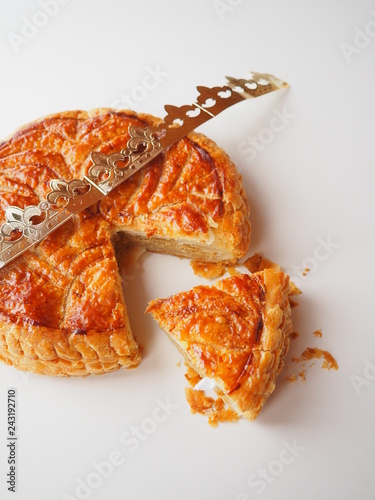 Homemade Epiphany cake or Twelfth Night cake (french galette des rois) made of puff pastry and frangipane (almond cream), white background