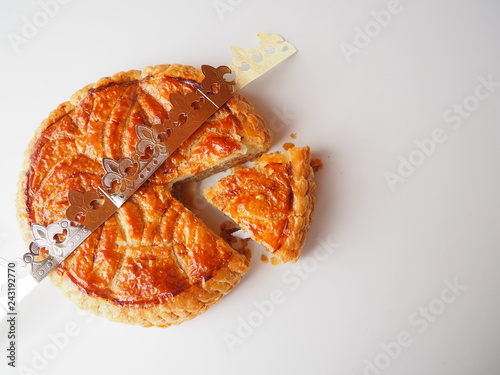 Homemade Epiphany cake or Twelfth Night cake (french galette des rois) made of puff pastry and frangipane (almond cream), white background