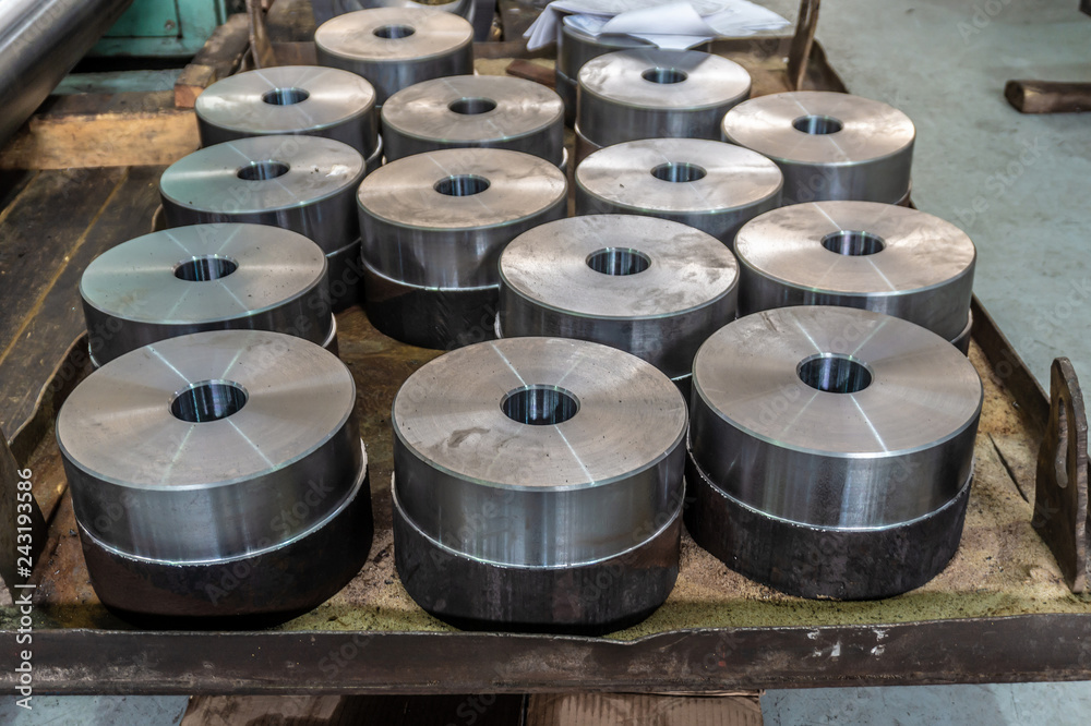 Round flat turning parts with an internal opening lie on a wooden warehouse. Round flat turning parts with an internal opening lie on a wooden warehouse.