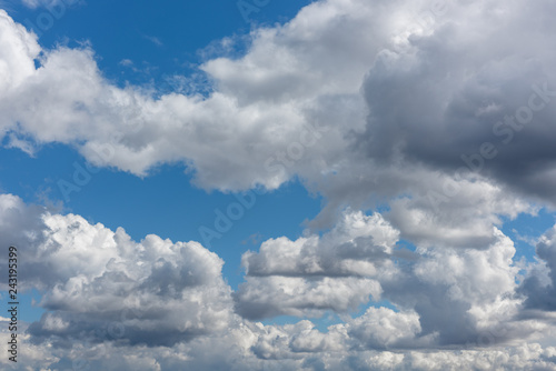 The blue sky with white clouds, in the rays of sunlight.