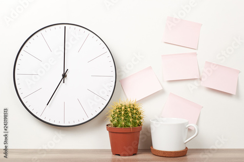 Wall clock, pink stickers, cactus and cup on a white background. Workspace mock up