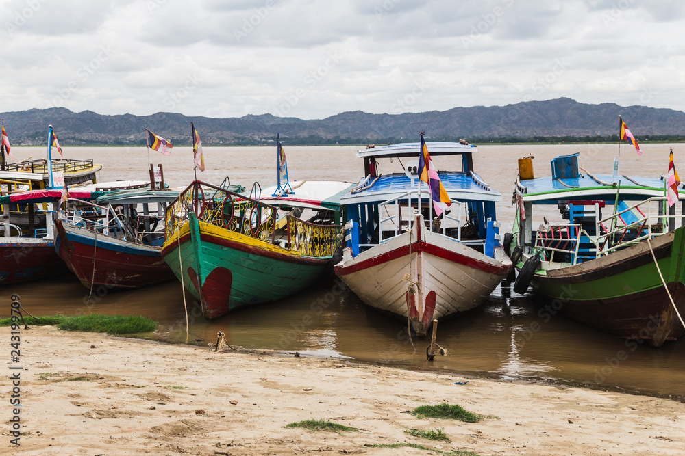 Colorful boats docked on shore in Bagan, Myanmar