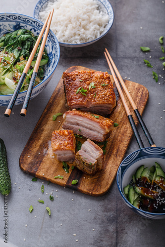 Chinese crispy skin pork belly with bok choy and cucmbers photo