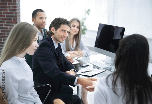 closeup.handshake trading partners,sitting behind a Desk. concept of partnership