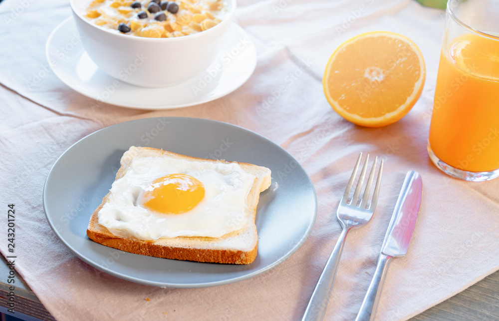 Toast with fried egg, orange juice and cornflakes with milk and berries. Healthy breakfast. Toast with fried egg, orange juice and cornflakes with milk and berries. Healthy breakfast.
