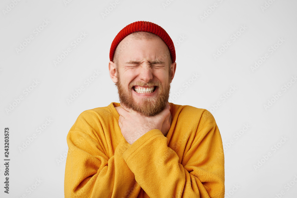 Close up of male in despair makes suicide gesture, keeps hands on neck, feels himself guilty, isolated over white background. Stressful concerned young man. Depression concept Close up of male in despair makes suicide gesture, keeps hands on neck, feels himself guilty, isolated over white background. Stressful concerned young man. Depression concept