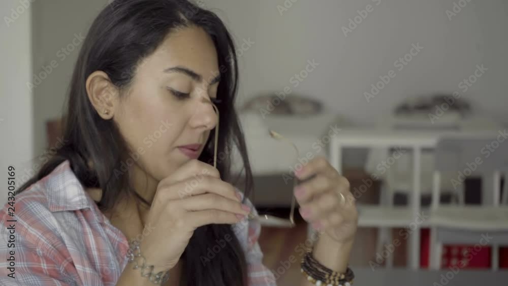 Exhausted hindu woman rubbing temple and holding eyeglasses. Tired young employee with headache working late. Overwork concept Exhausted hindu woman rubbing temple and holding eyeglasses. Tired young employee with headache working late. Overwork concept