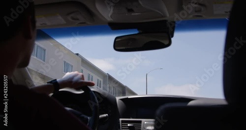 Man driving car through low income housing - view from the back seat looking out windsheild photo