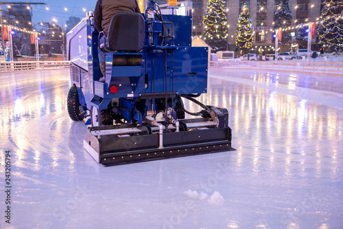A machine for restoring or smoothing ice rides on an ice rink in the evening.