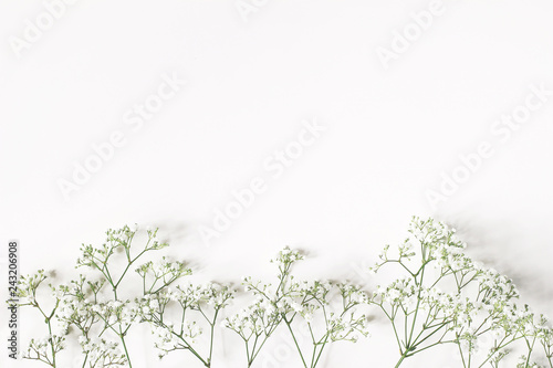 Fototapeta Naklejka Na Ścianę i Meble -  Styled stock photo. Feminine wedding, birthday composition with baby's breath Gypsophila flowers. White table background. Empty space. Floral frame, web banner. Top view.