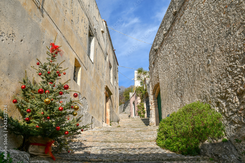 Narrow stone lane in the ancient village of Borgio Verezzi with Christmas tree during holidays, Liguria, Italy