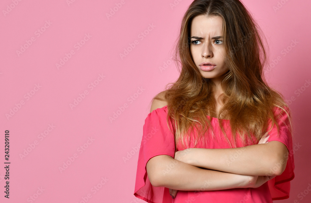 Portrait of an upset woman standing with arms folded and looking away
