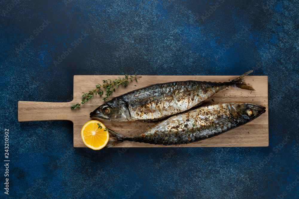 Baked mackerel fish on blue background, top view