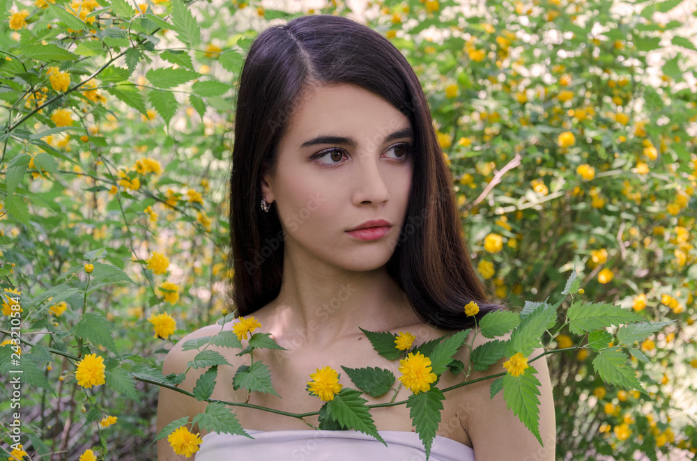 beautiful young girl with dark long hair surrounded by yellow flowers beautiful young girl with dark long hair surrounded by yellow flowers