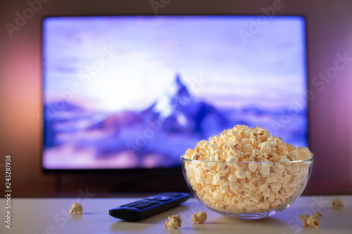 Canvas-taulu A glass bowl of popcorn and remote control in the background the TV works