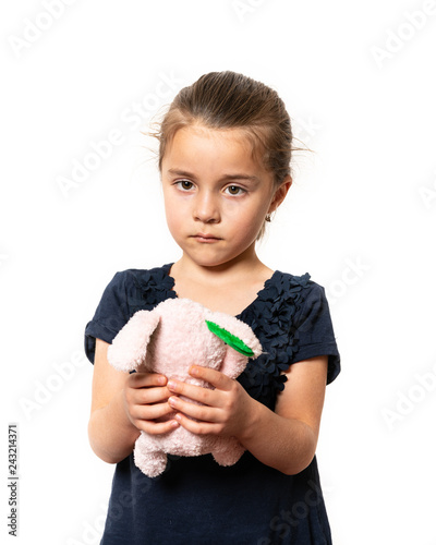 Preschooler holding teddy bear over isolated background serious face thinking about question, very confused idea