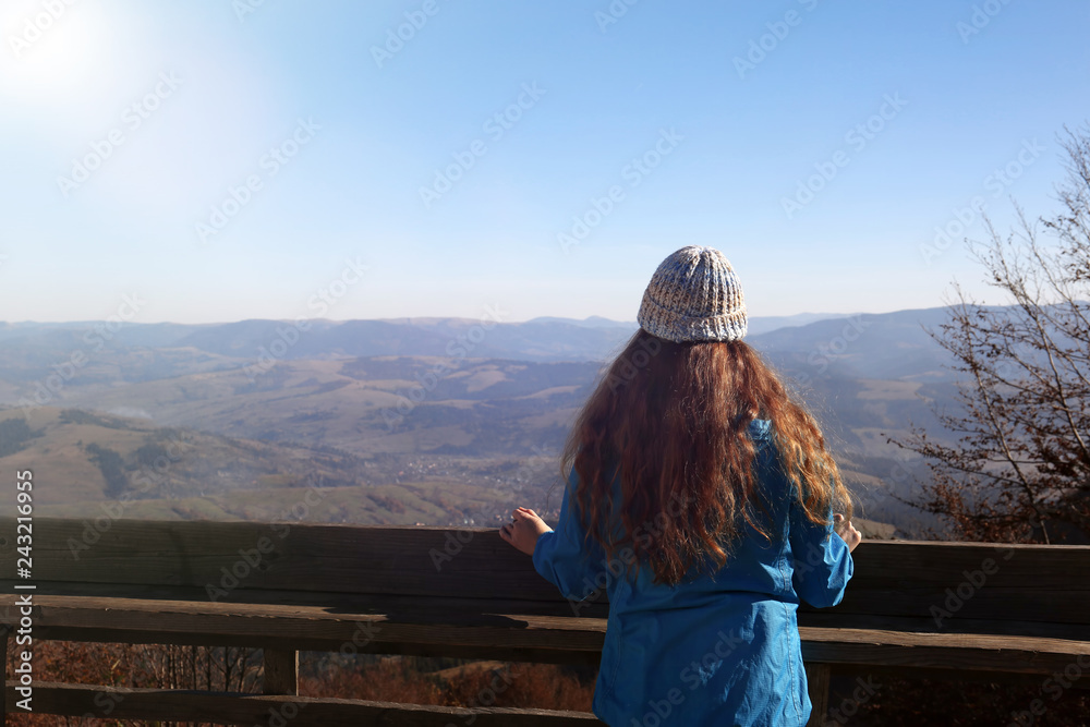 Woman in warm clothes enjoying mountain landscape