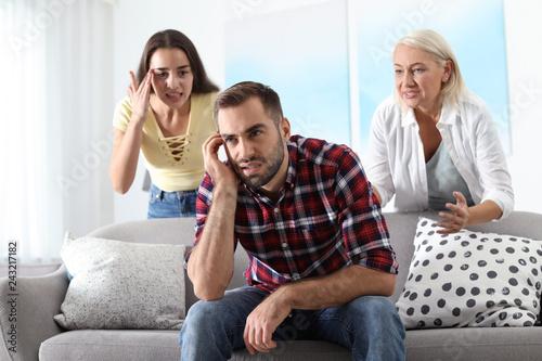 Young man having argument with wife and mother-in-law at home. Family quarrel
