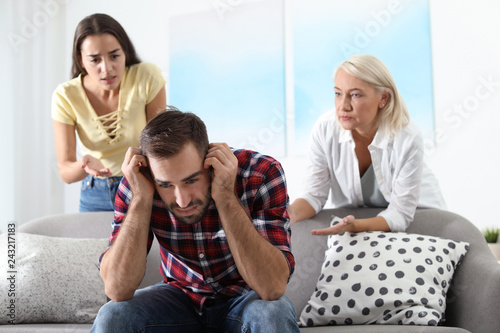 Young man having argument with wife and mother-in-law at home. Family quarrel