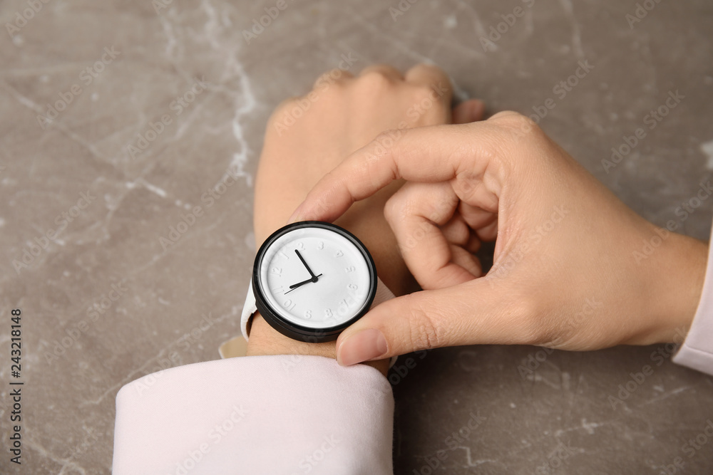 Fototapeta premium Businesswoman with stylish wrist watch at table, closeup. Time management
