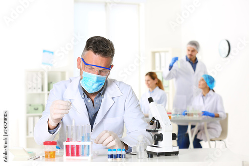 Male scientist working at table in laboratory, space for text. Research and analysis