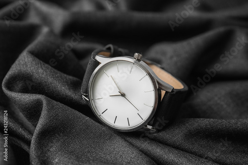Stylish wrist watch on dark fabric. Fashion accessory