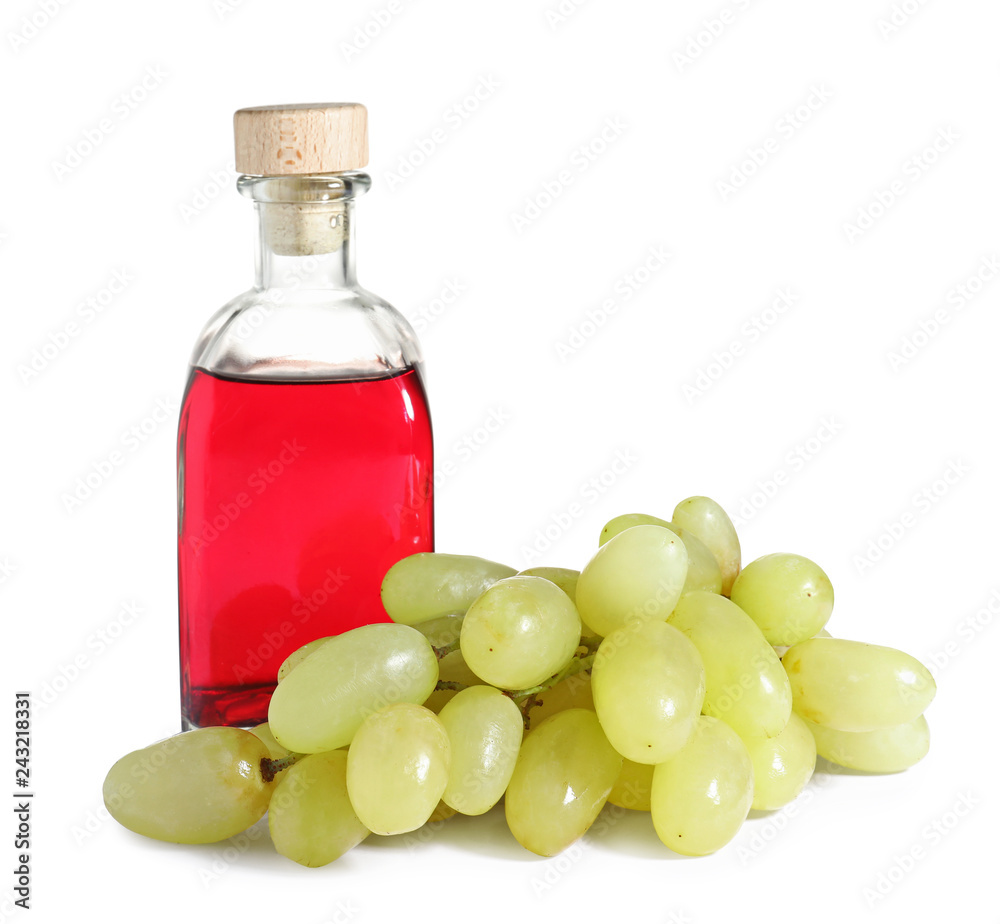 Glass bottle with wine vinegar and fresh grapes on white background Glass bottle with wine vinegar and fresh grapes on white background