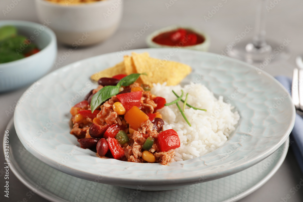 Tasty chili con carne served with rice on gray table Tasty chili con carne served with rice on gray table