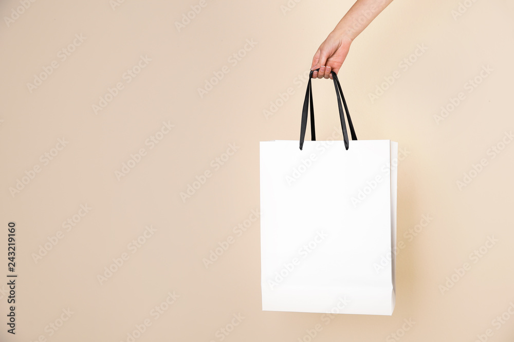 Woman holding paper shopping bag on color background. Mock up for design - obrazy, fototapety, plakaty 